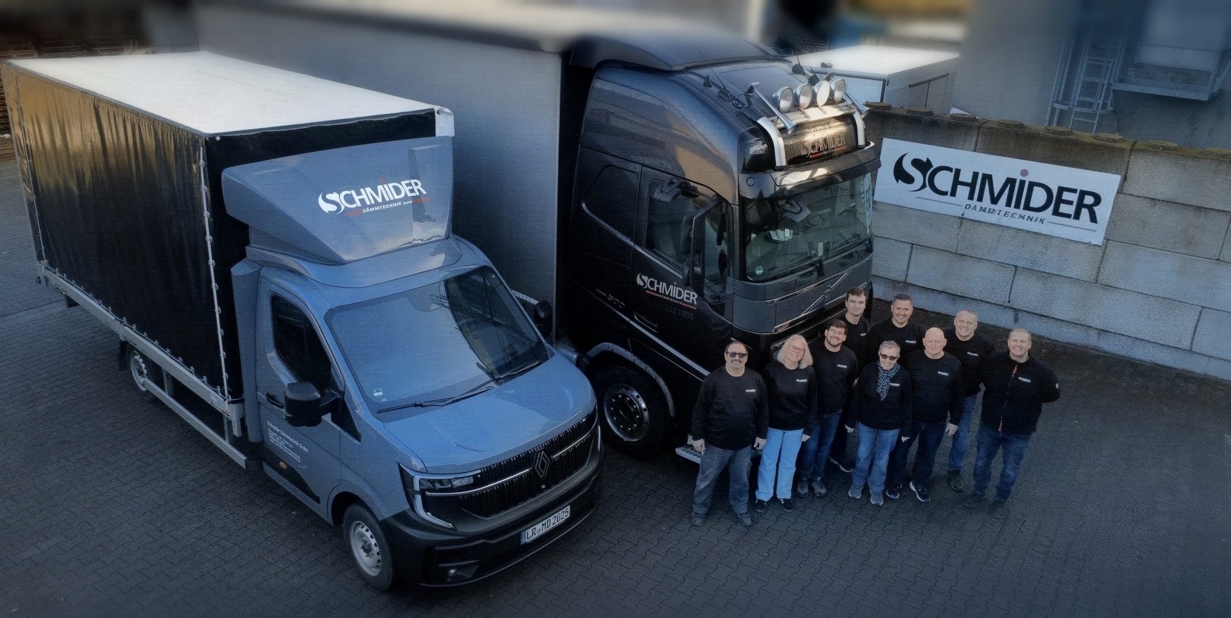 Das Team von Schmider Dämmtechnik vor den eigenen Lkw und dem Firmenschild in Lahr
